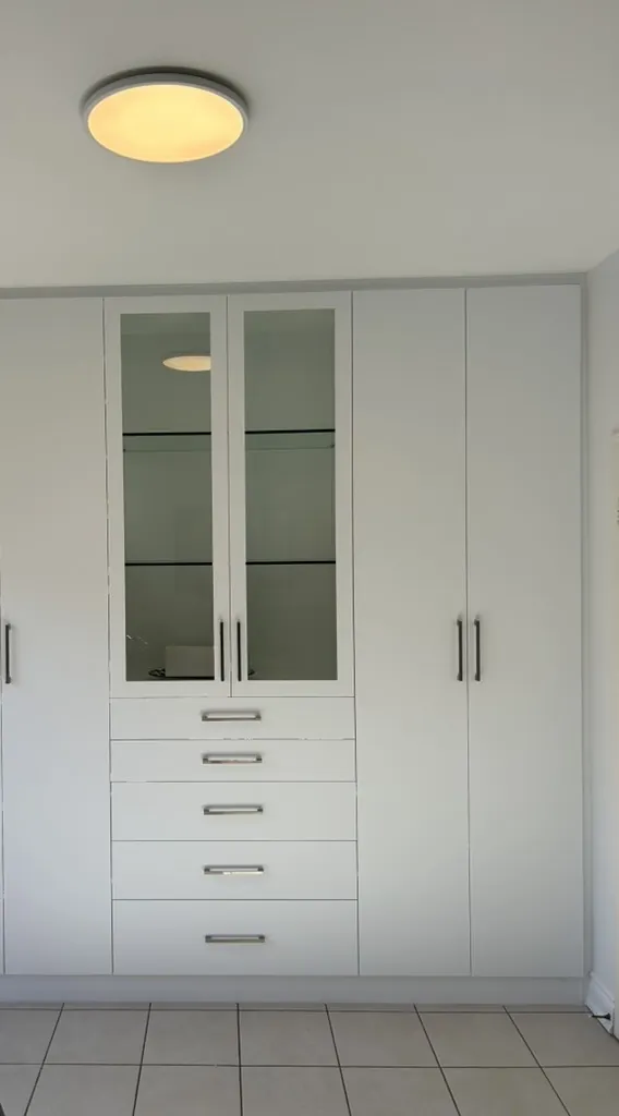 Custom wardrobe with glass display doors by Newood Millwork
