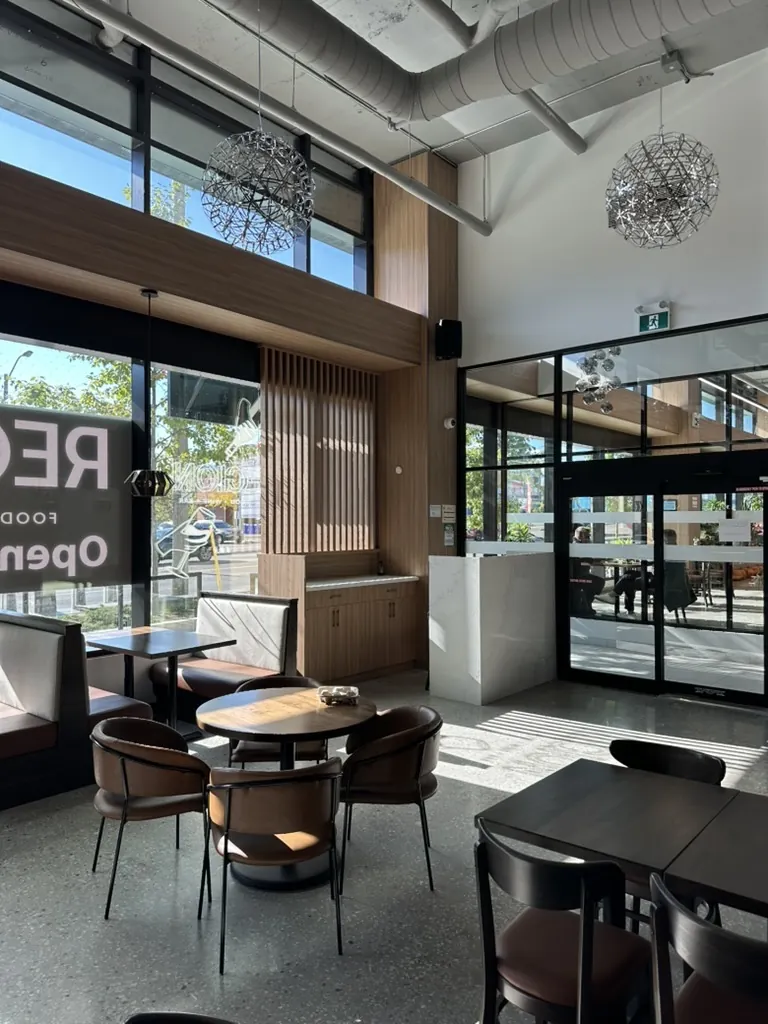 Café seating area with custom wood slat feature wall by Newood Millwork