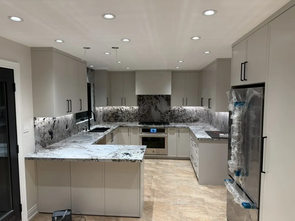 Custom kitchen renovation with waterfall stone countertops by Newood Millwork
