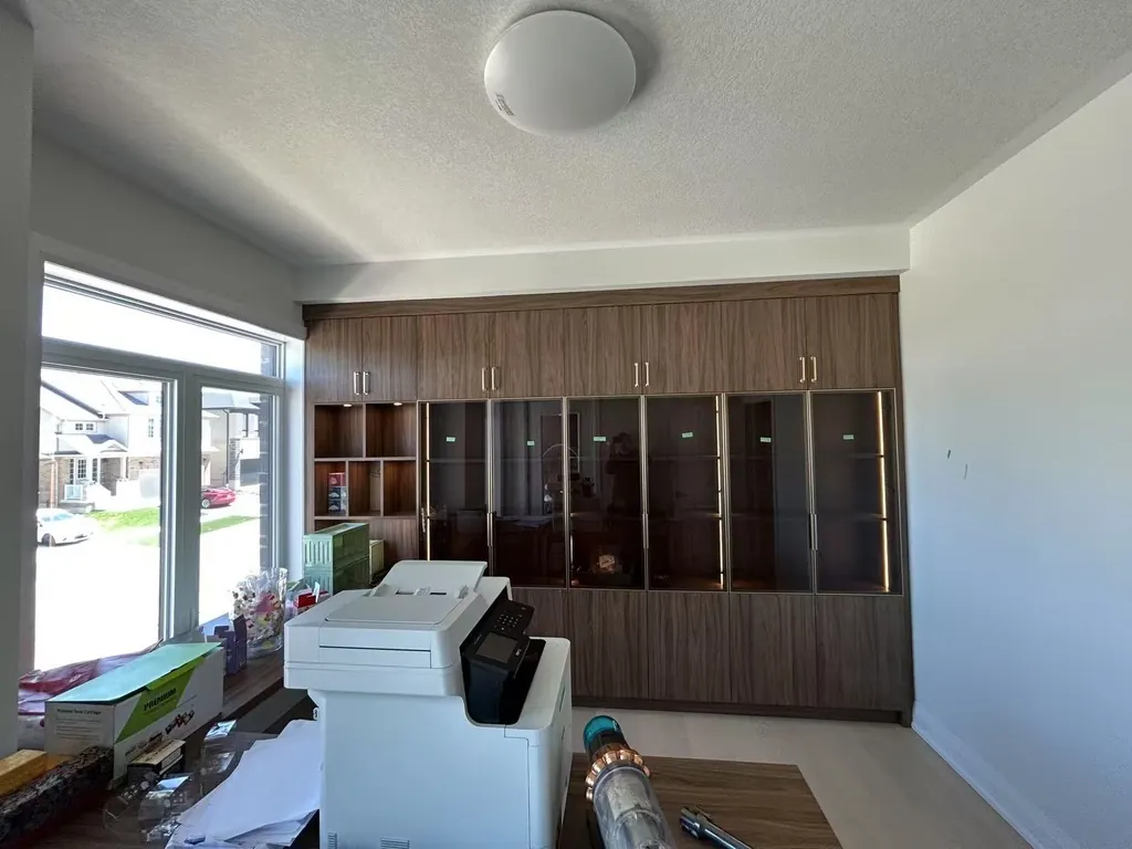 Custom home office cabinetry with integrated lighting by Newood Millwork